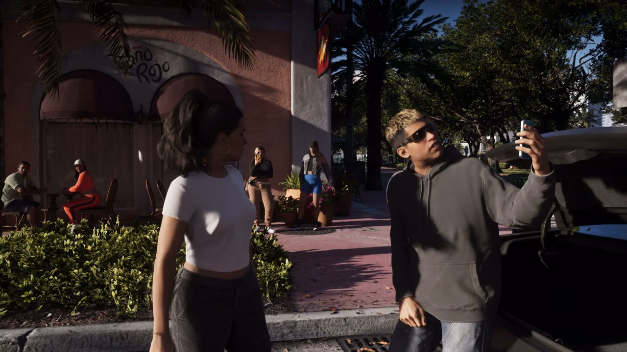 An NPC physically filming Lucia with a phone while a social-video overlay is visible in Rockstar's Extended Look